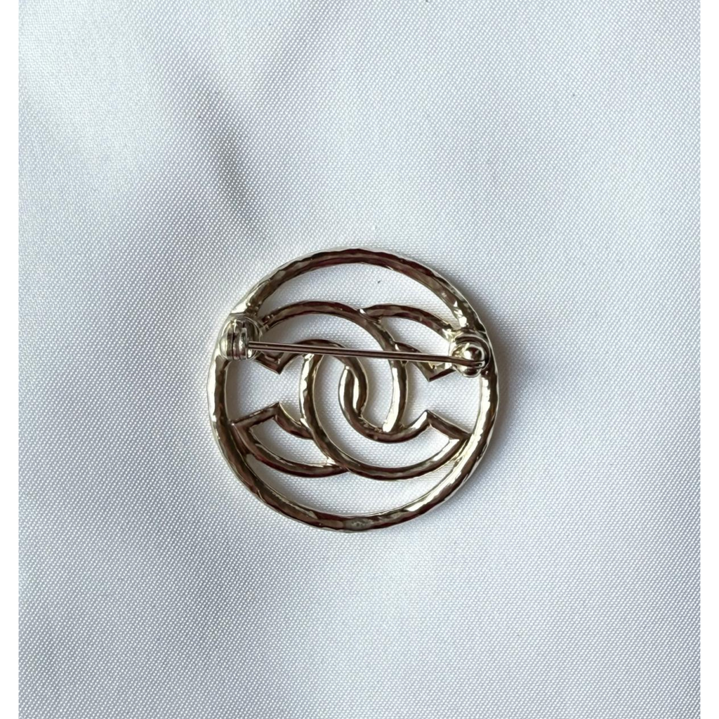 Chanel Brosche, CC